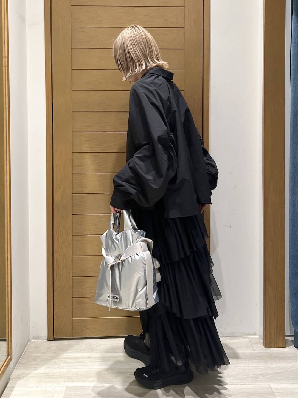 シルバー系のトートバッグ、ブラック系のシャツ/ブラウス、ブラック系のスカートを着用したレディースの春コーディネートの6枚目の写真