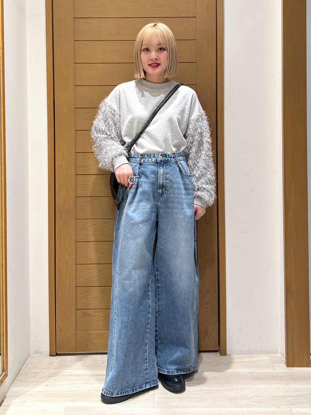 ブルー系のデニムパンツ、その他のローファー、ブラック系のショルダーバッグを着用したレディースの冬コーディネートの5枚目の写真