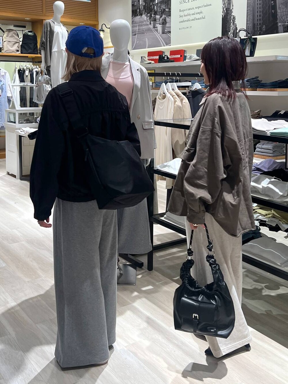 ブラック系のブルゾン、ブラック系のハンドバッグ、グリーン系のカバーオールを着用したレディースの春コーディネートの3枚目の写真