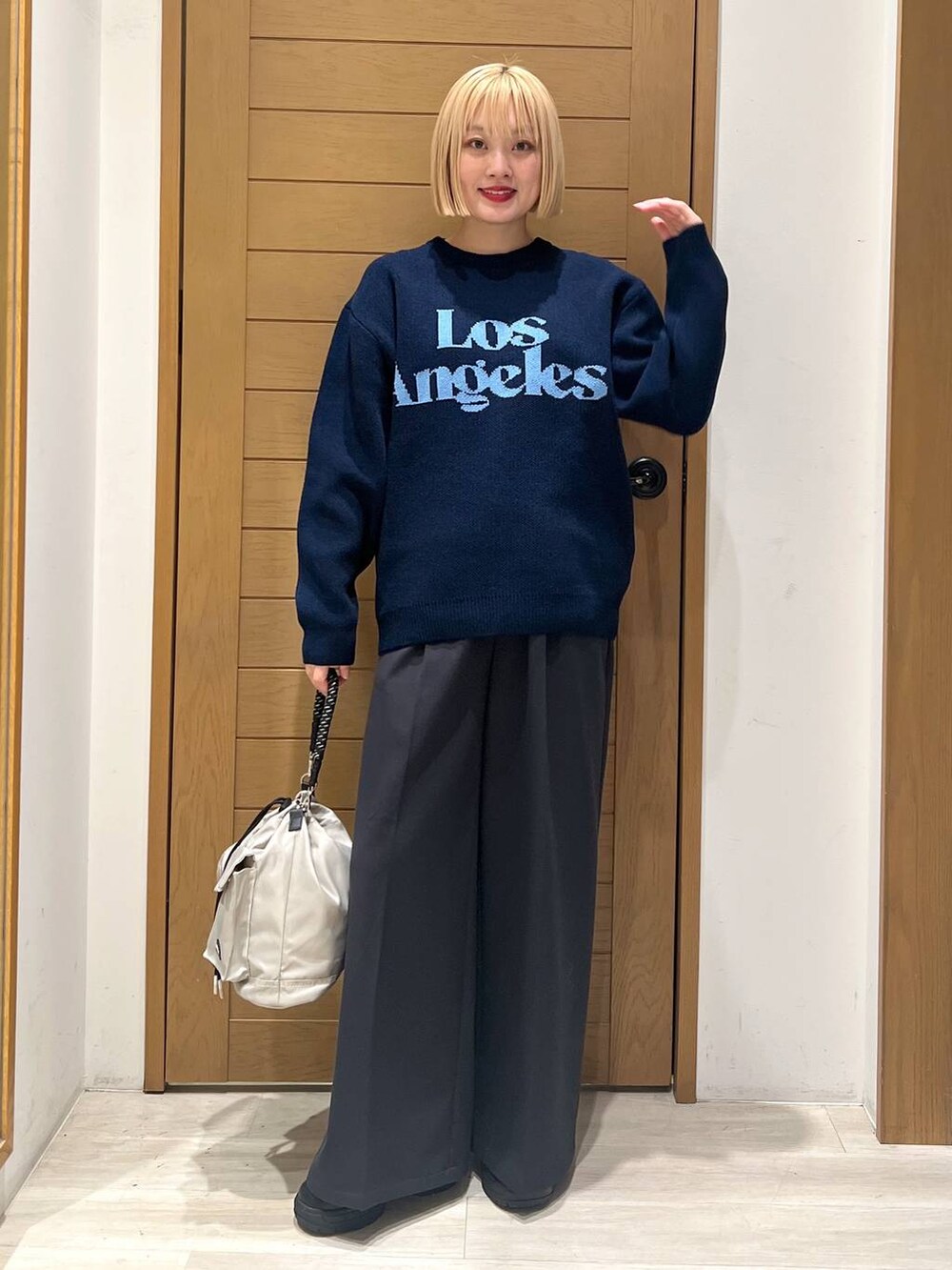 グレー系のショルダーバッグ、ブラック系のブーツ、ブラック系のその他パンツを着用したレディースの冬コーディネートの5枚目の写真