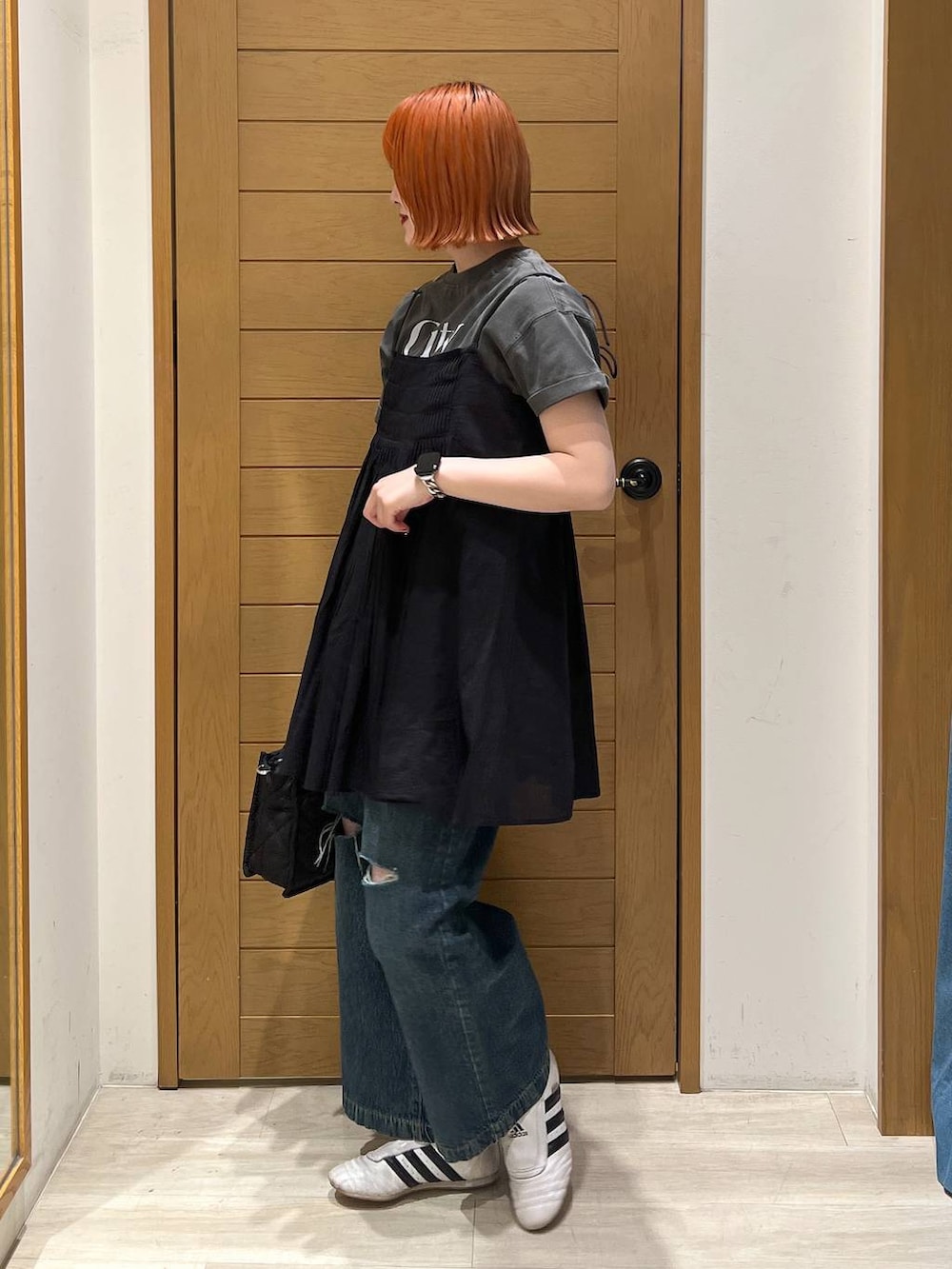 グレー系のTシャツ/カットソー、ブルー系のデニムパンツ、ブラック系のショルダーバッグを着用したレディースの夏コーディネートの4枚目の写真