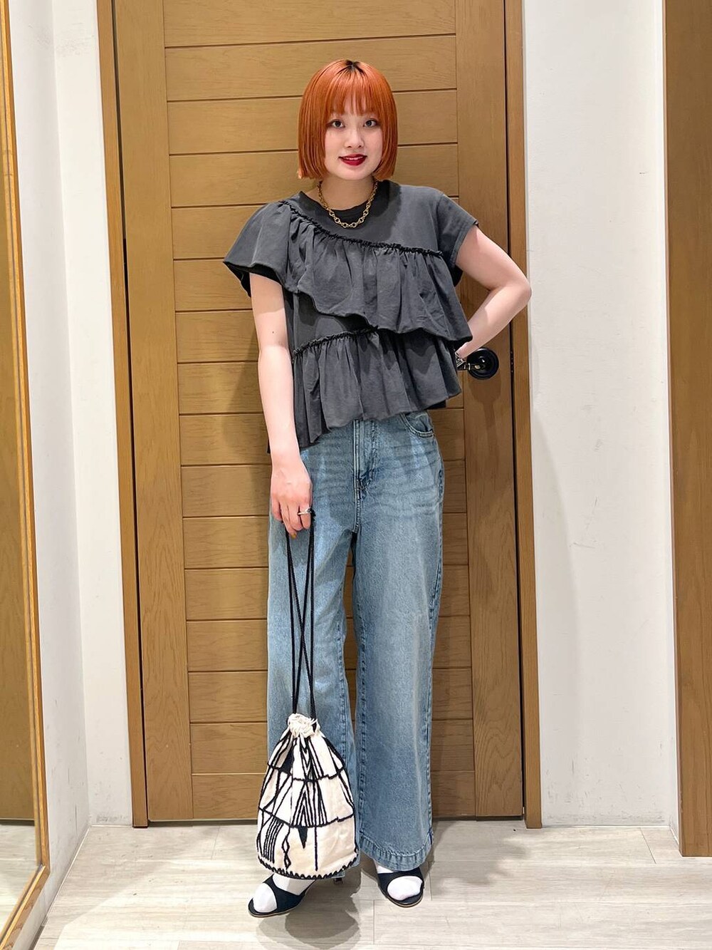 ブルー系のデニムパンツ、ブラック系のサンダル、グレー系のTシャツ/カットソーを着用したレディースの夏コーディネートの4枚目の写真