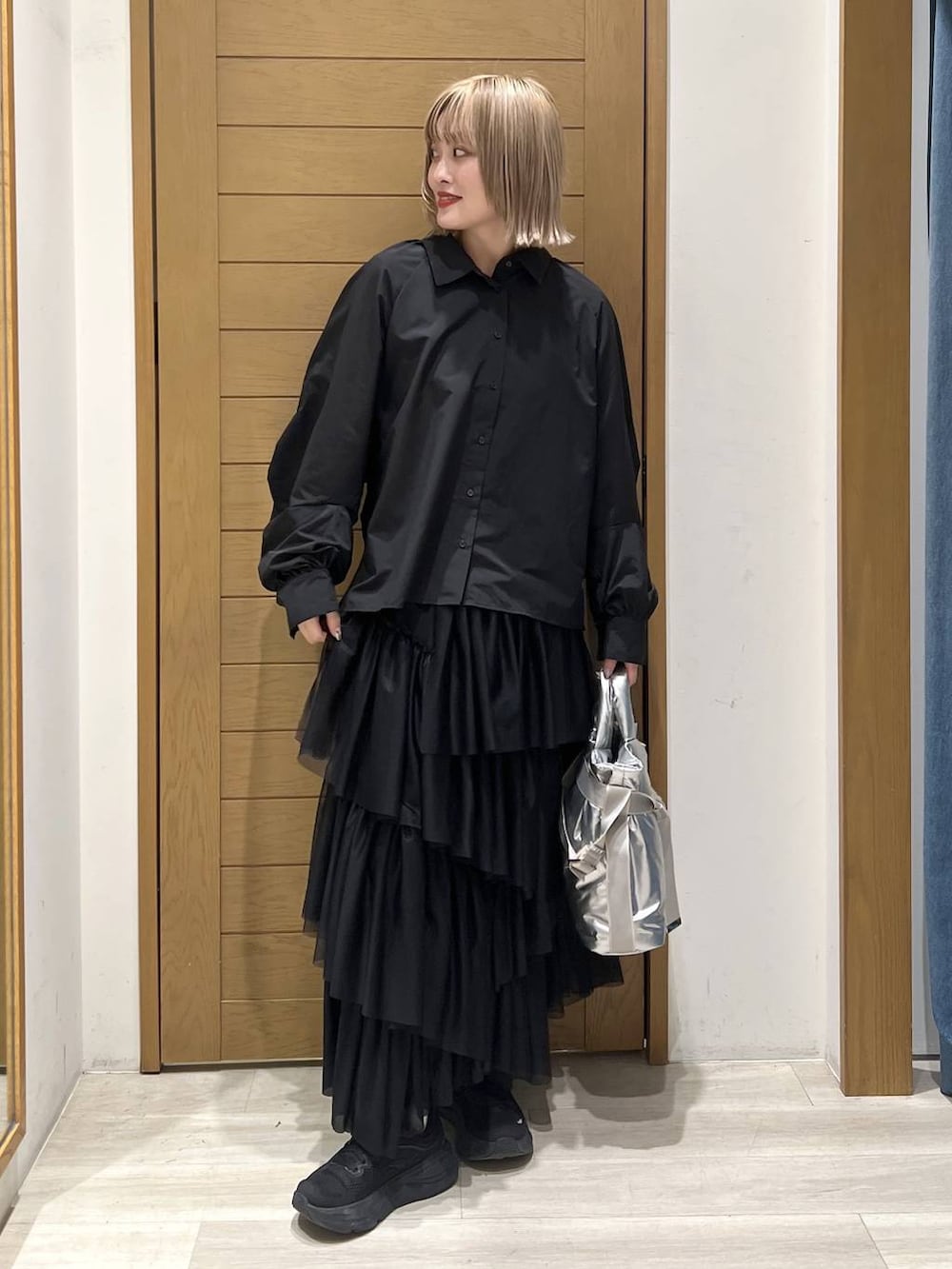 シルバー系のトートバッグ、ブラック系のシャツ/ブラウス、ブラック系のスカートを着用したレディースの春コーディネートの4枚目の写真