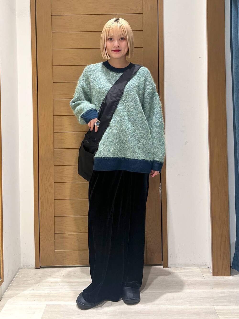 グリーン系のニット/セーター、ブラック系のショルダーバッグ、ブラック系のその他パンツを着用したレディースの冬コーディネートの5枚目の写真