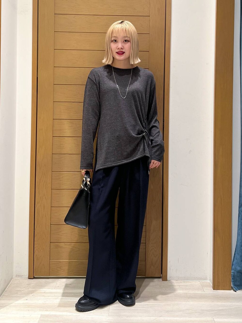 ブラック系のハンドバッグ、ブルー系のその他パンツ、その他のローファーを着用したレディースの冬コーディネートの3枚目の写真