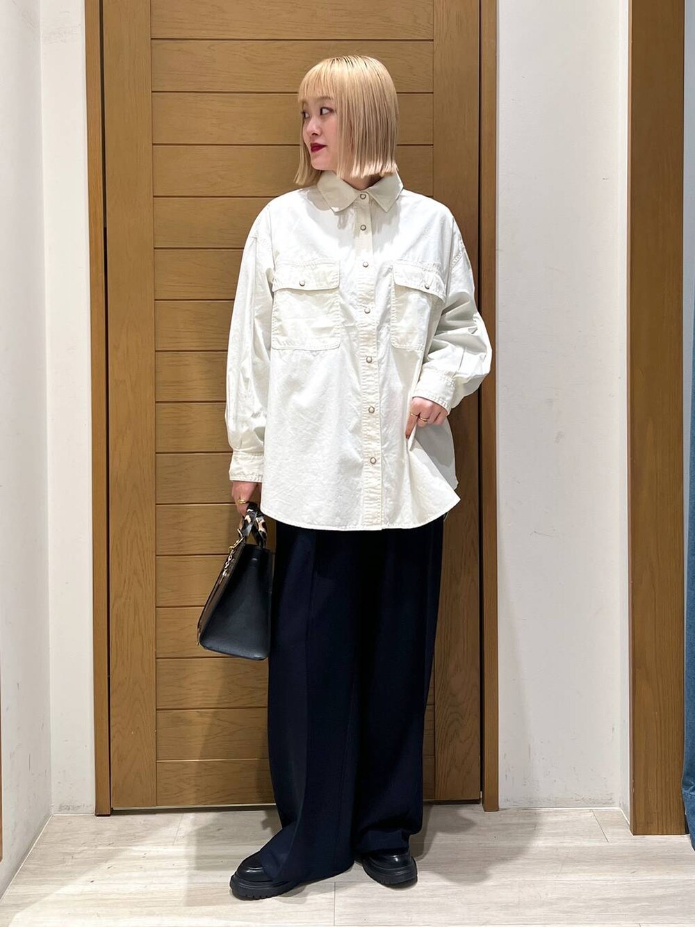 ブラック系のハンドバッグ、ブルー系のその他パンツ、その他のローファーを着用したレディースの冬コーディネートの4枚目の写真