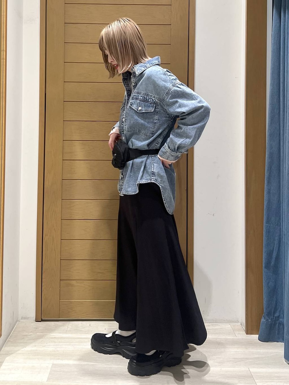 ブルー系のシャツ/ブラウス、ブラック系のスニーカー、ピンク系のニット/セーターを着用したレディースの春コーディネートの3枚目の写真