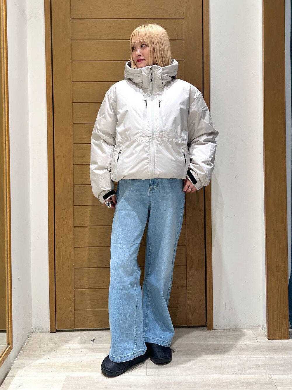 ホワイト系のダウンジャケット/コート、ブルー系のデニムパンツを着用したレディースの冬コーディネートの4枚目の写真