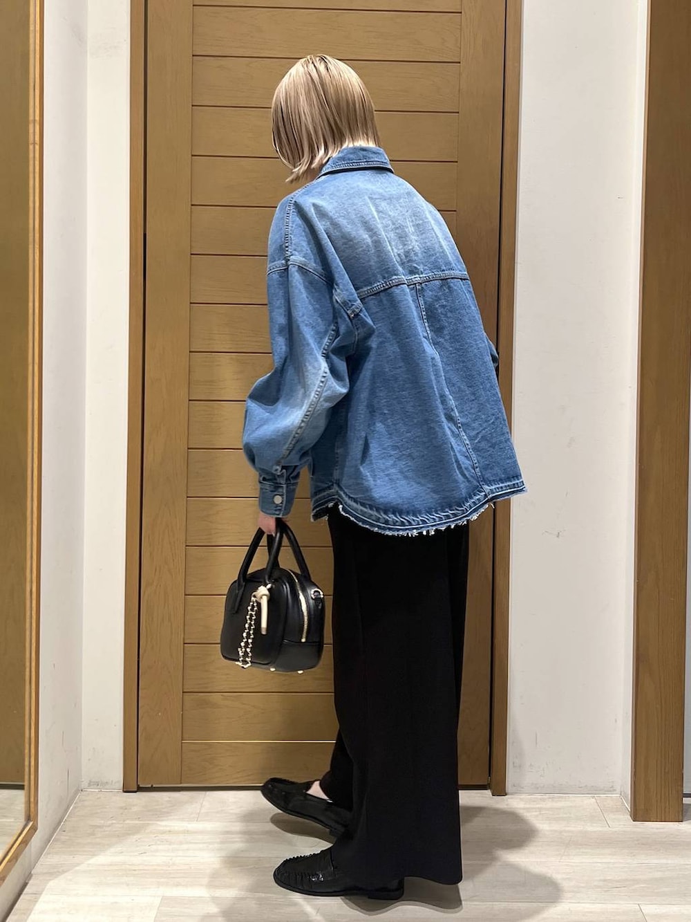 ブラック系のその他パンツ、ブラック系のローファー、ブラック系のハンドバッグを着用したレディースの春コーディネートの3枚目の写真