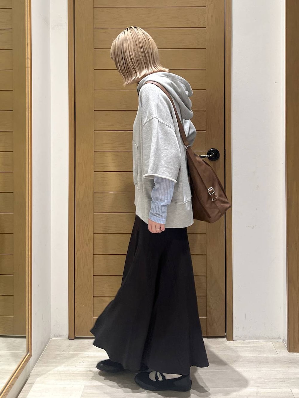 ブラック系のバレエシューズ、ブラック系のトートバッグ、ブルー系のTシャツ/カットソーを着用したレディースの春コーディネートの4枚目の写真