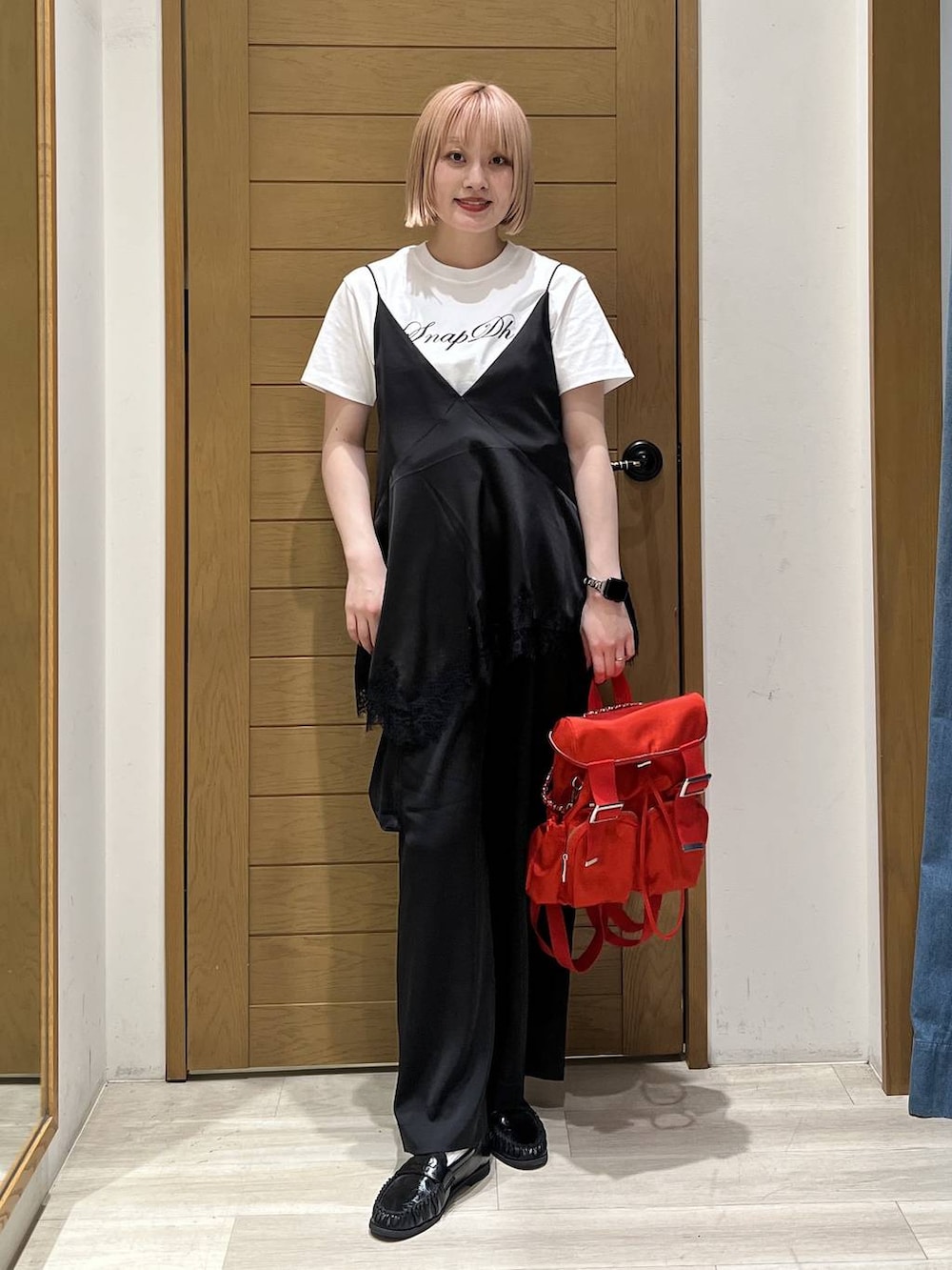 レッド系のバックパック/リュック、ブラック系のキャミソール、ホワイト系のTシャツ/カットソーを着用したレディースの春コーディネートの3枚目の写真