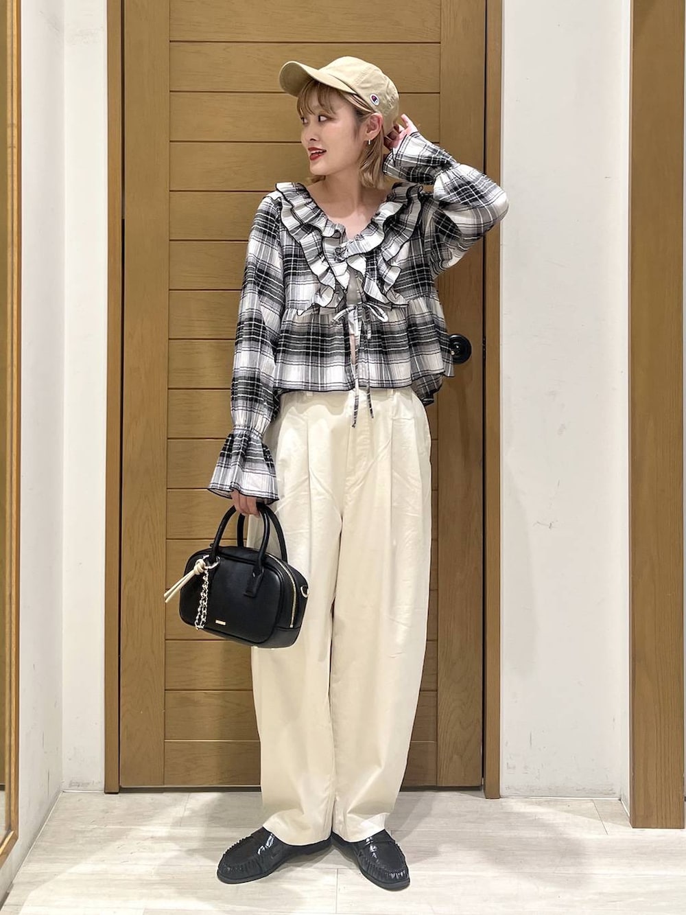 ホワイト系のその他パンツ、ブラック系のハンドバッグ、ブラック系のシャツ/ブラウスを着用したレディースの春コーディネートの3枚目の写真