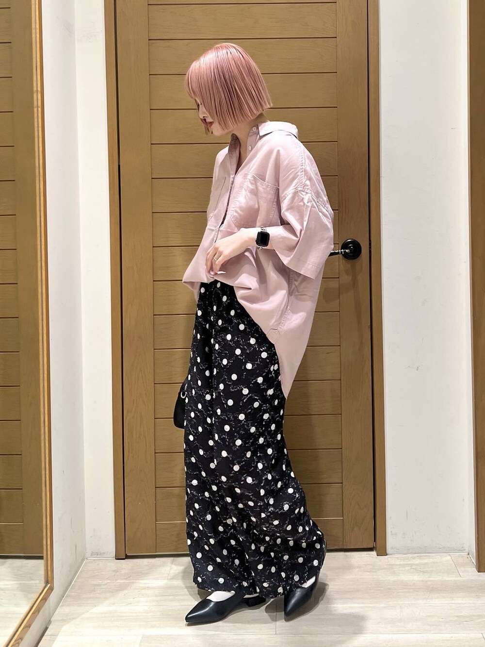 パープル系のシャツ/ブラウス、ブラック系のパンプス、ブラック系のハンドバッグを着用したレディースの春コーディネートの3枚目の写真
