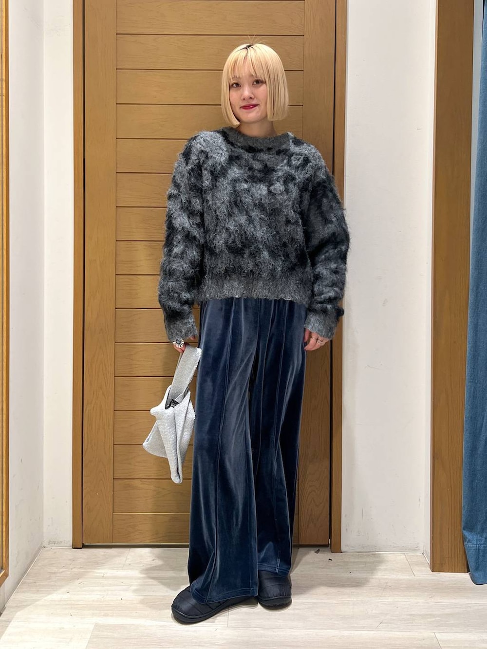 ブルー系のその他パンツ、グレー系のハンドバッグ、グレー系のニット/セーターを着用したレディースの冬コーディネートの4枚目の写真