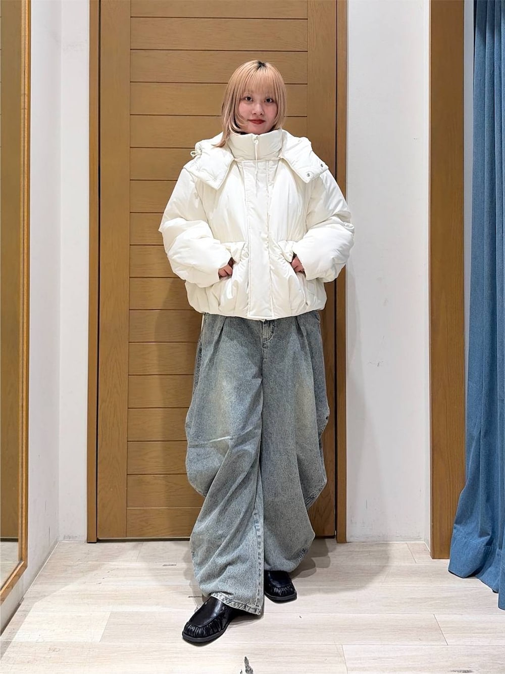 ブラック系のスリッポン、ブルー系のデニムパンツ、ホワイト系のブルゾンを着用したレディースの秋コーディネートの6枚目の写真