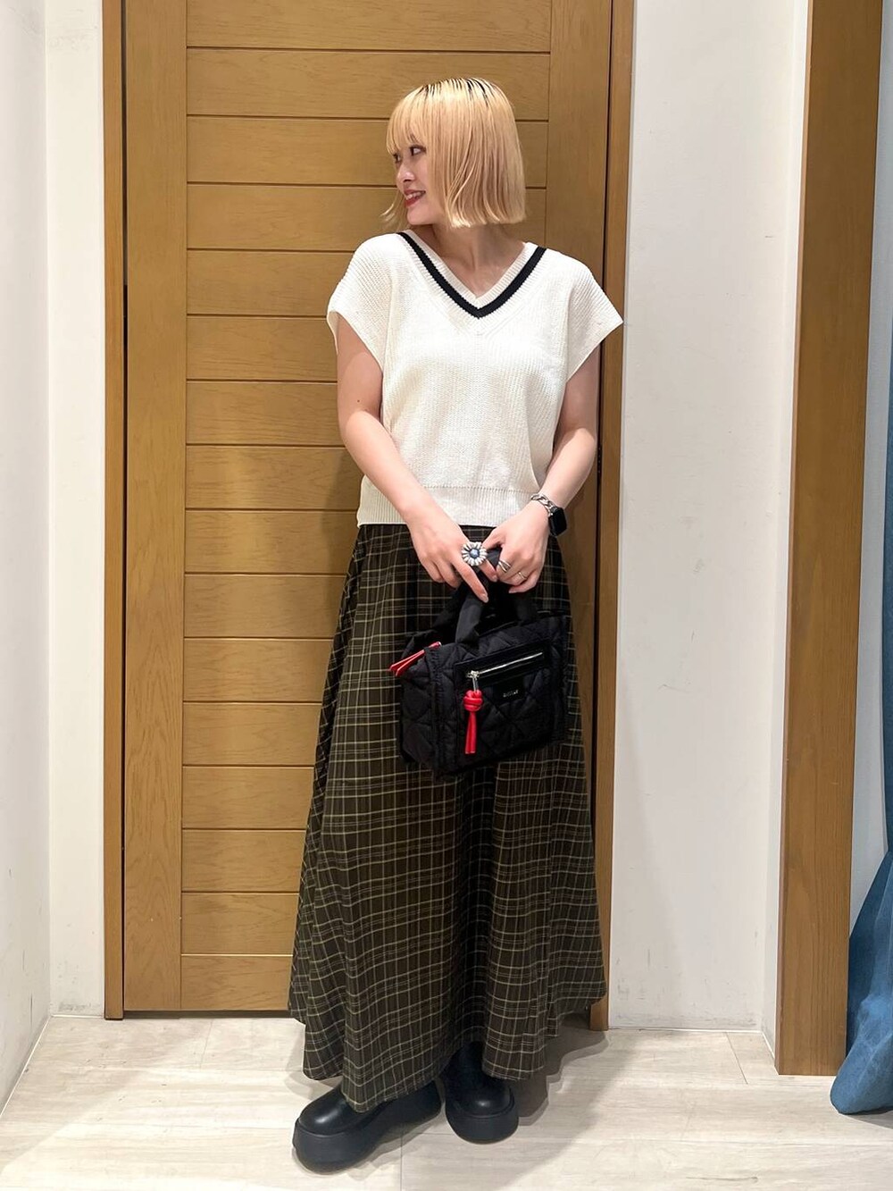 ブラック系のショルダーバッグ、ブラック系のサンダル、ホワイト系のニット/セーターを着用したレディースの秋コーディネートの2枚目の写真