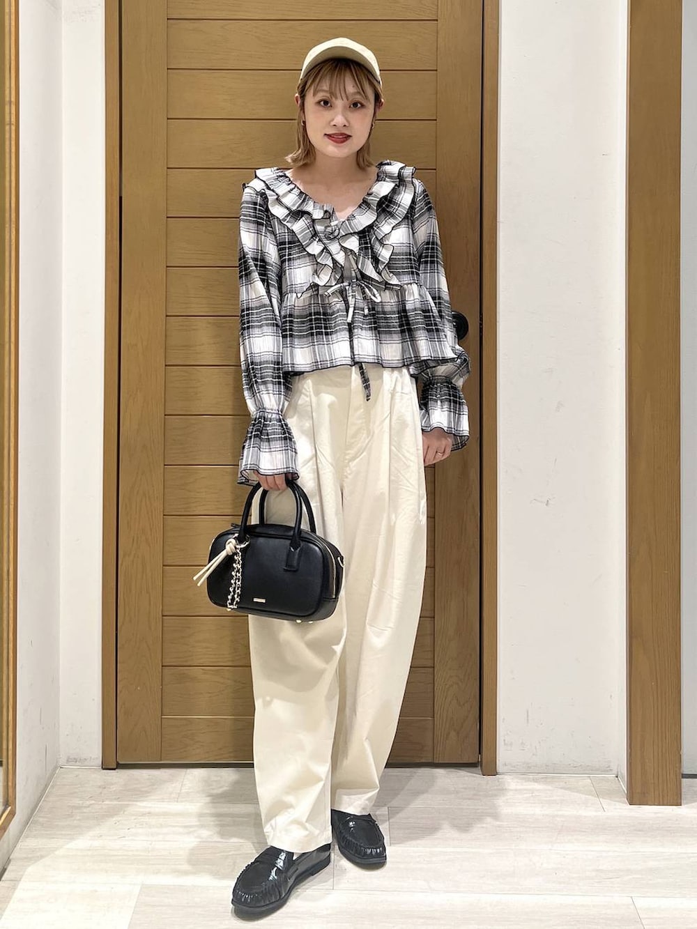 ホワイト系のその他パンツ、ブラック系のハンドバッグ、ブラック系のシャツ/ブラウスを着用したレディースの春コーディネートの4枚目の写真