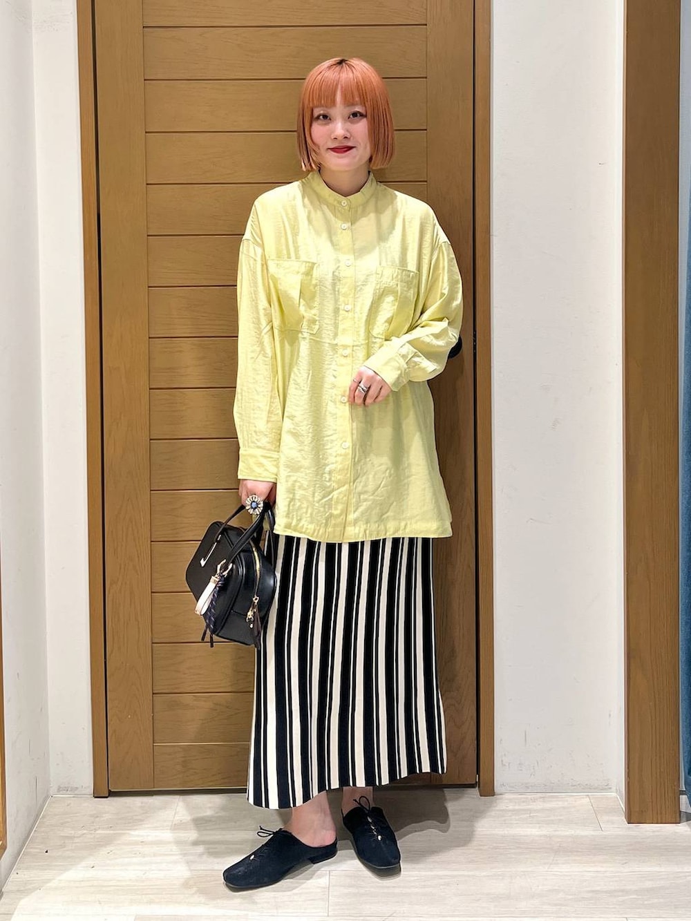 イエロー系のシャツ/ブラウス、ブラック系のショルダーバッグ、ブラック系のその他シューズを着用したレディースの春コーディネートの5枚目の写真