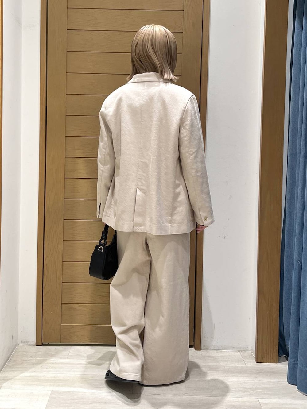 レッド系のTシャツ/カットソー、ブラック系のハンドバッグ、ブラック系のローファーを着用したレディースの春コーディネートの4枚目の写真