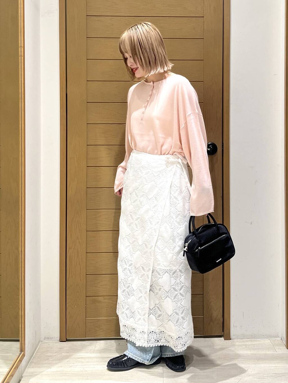 ブルー系のデニムパンツ、ブラック系のハンドバッグ、ブラック系のローファーを着用したレディースの春コーディネートの3枚目の写真