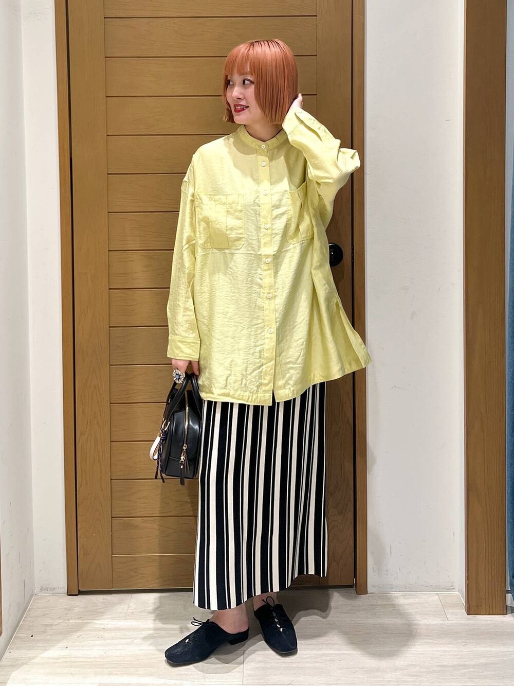 イエロー系のシャツ/ブラウス、ブラック系のショルダーバッグ、ブラック系のその他シューズを着用したレディースの春コーディネートの2枚目の写真