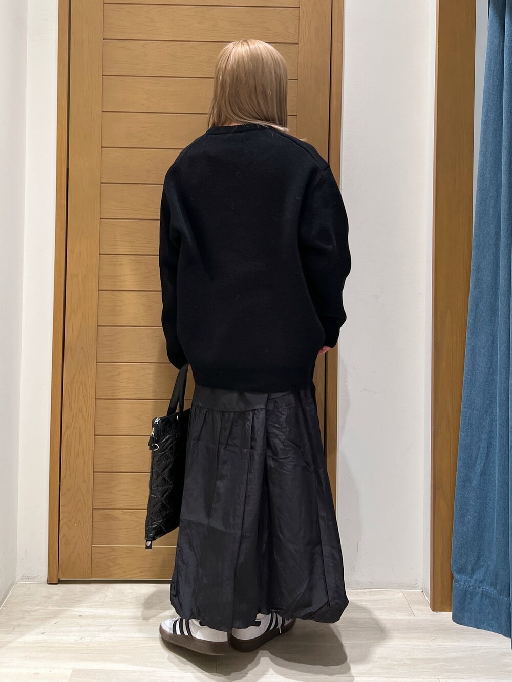 ブラック系のニット/セーター、ブラック系のスカート、ブラック系のトートバッグを着用したレディースの冬コーディネートの4枚目の写真