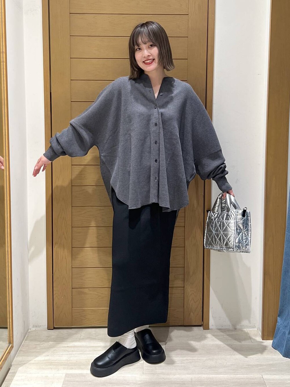 グレー系のカーディガン/ボレロ、シルバー系のショルダーバッグ、ブラック系のサンダルを着用したレディースの秋コーディネートの3枚目の写真