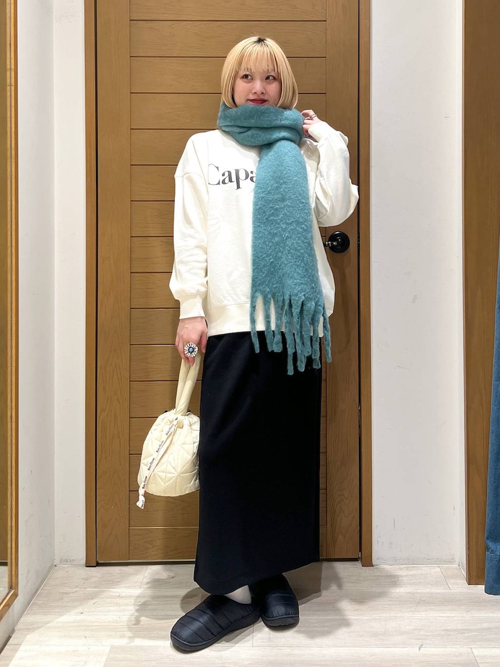 ベージュ系のショルダーバッグ、ホワイト系のスウェット、ブラック系のスカートを着用したレディースの冬コーディネートの5枚目の写真