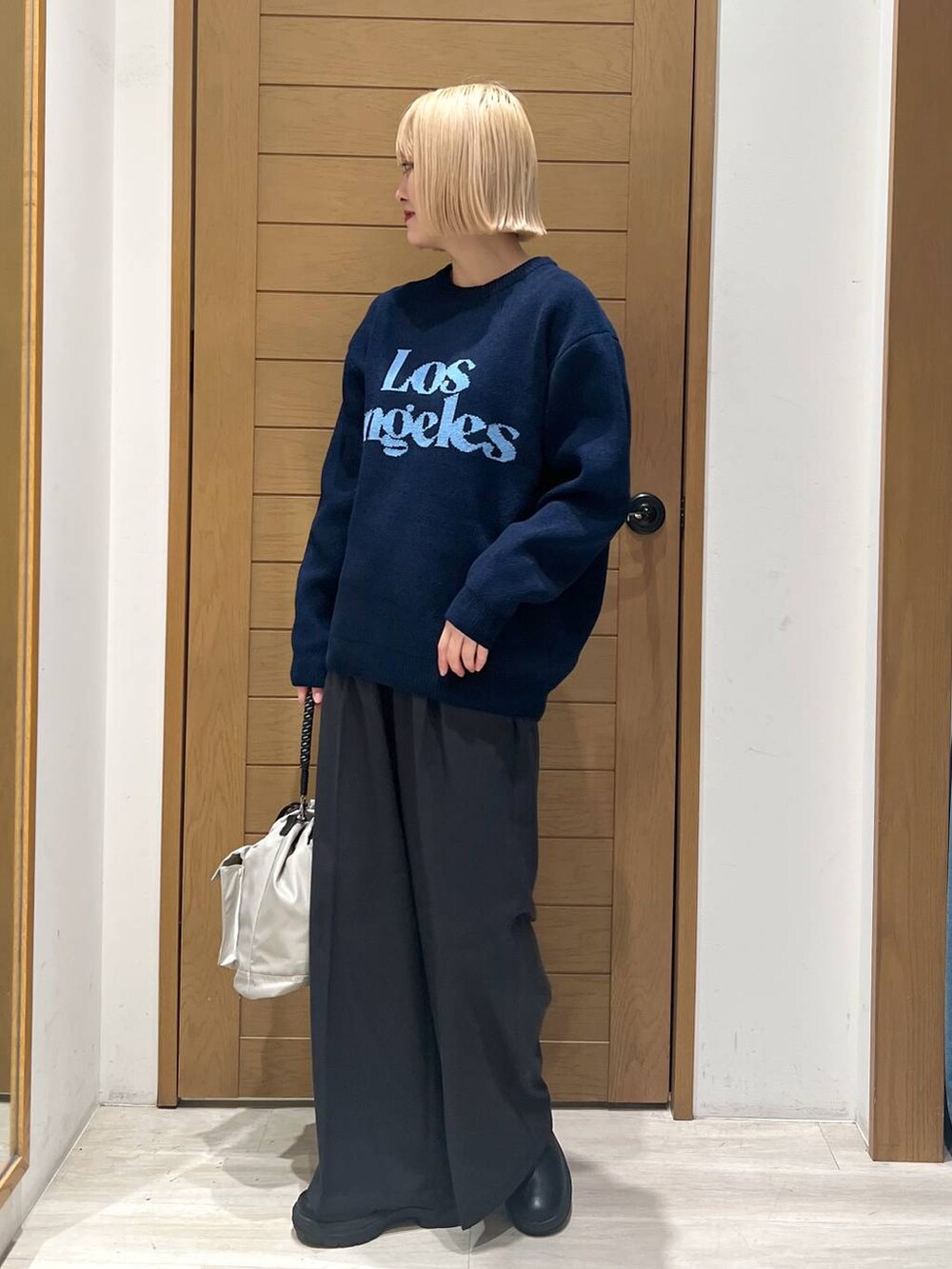 グレー系のショルダーバッグ、ブラック系のブーツ、ブラック系のその他パンツを着用したレディースの冬コーディネートの3枚目の写真