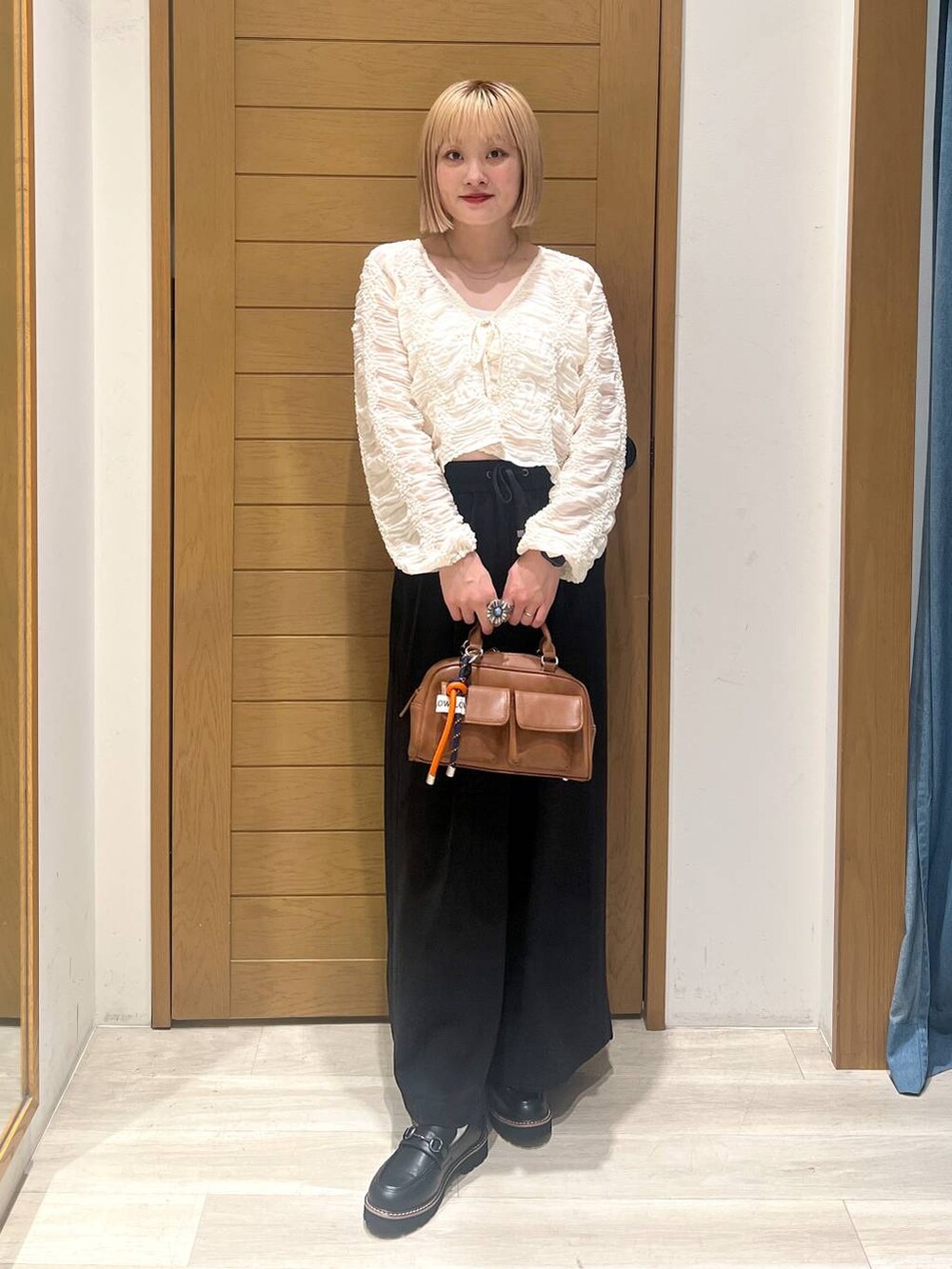 ブラック系のその他パンツ、ブラウン系のボストンバッグ、ブラック系のローファーを着用したレディースの秋コーディネートの3枚目の写真