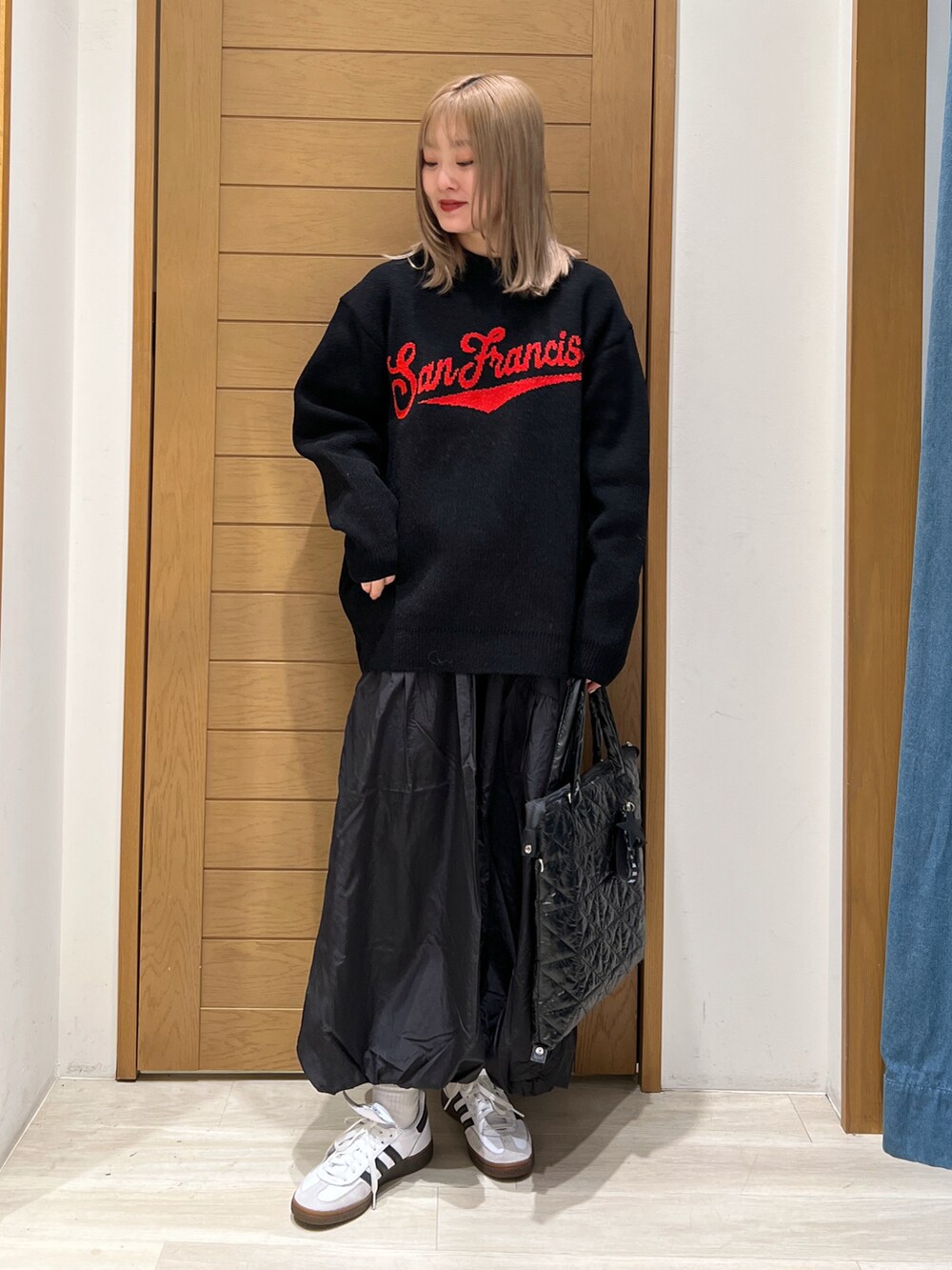 ブラック系のニット/セーター、ブラック系のスカート、ブラック系のトートバッグを着用したレディースの冬コーディネートの3枚目の写真