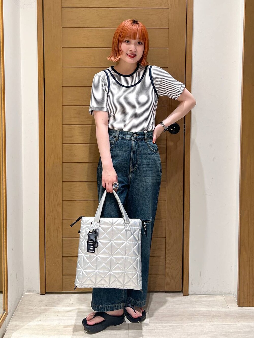 ブラック系のサンダル、ホワイト系のTシャツ/カットソー、シルバー系のトートバッグを着用したレディースの夏コーディネートの2枚目の写真