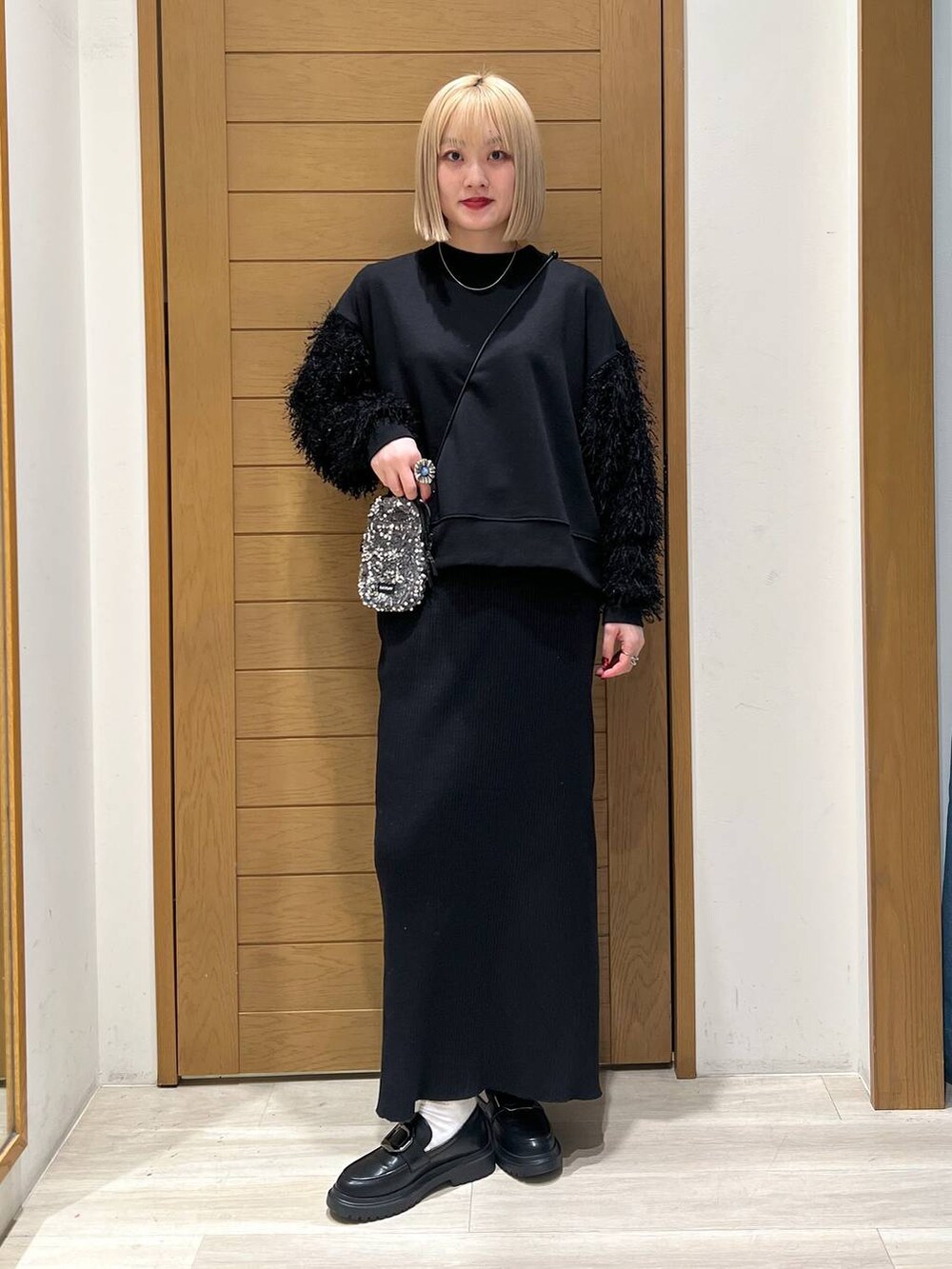 グレー系のショルダーバッグ、その他のローファー、ブラック系のスカートを着用したレディースの冬コーディネートの6枚目の写真