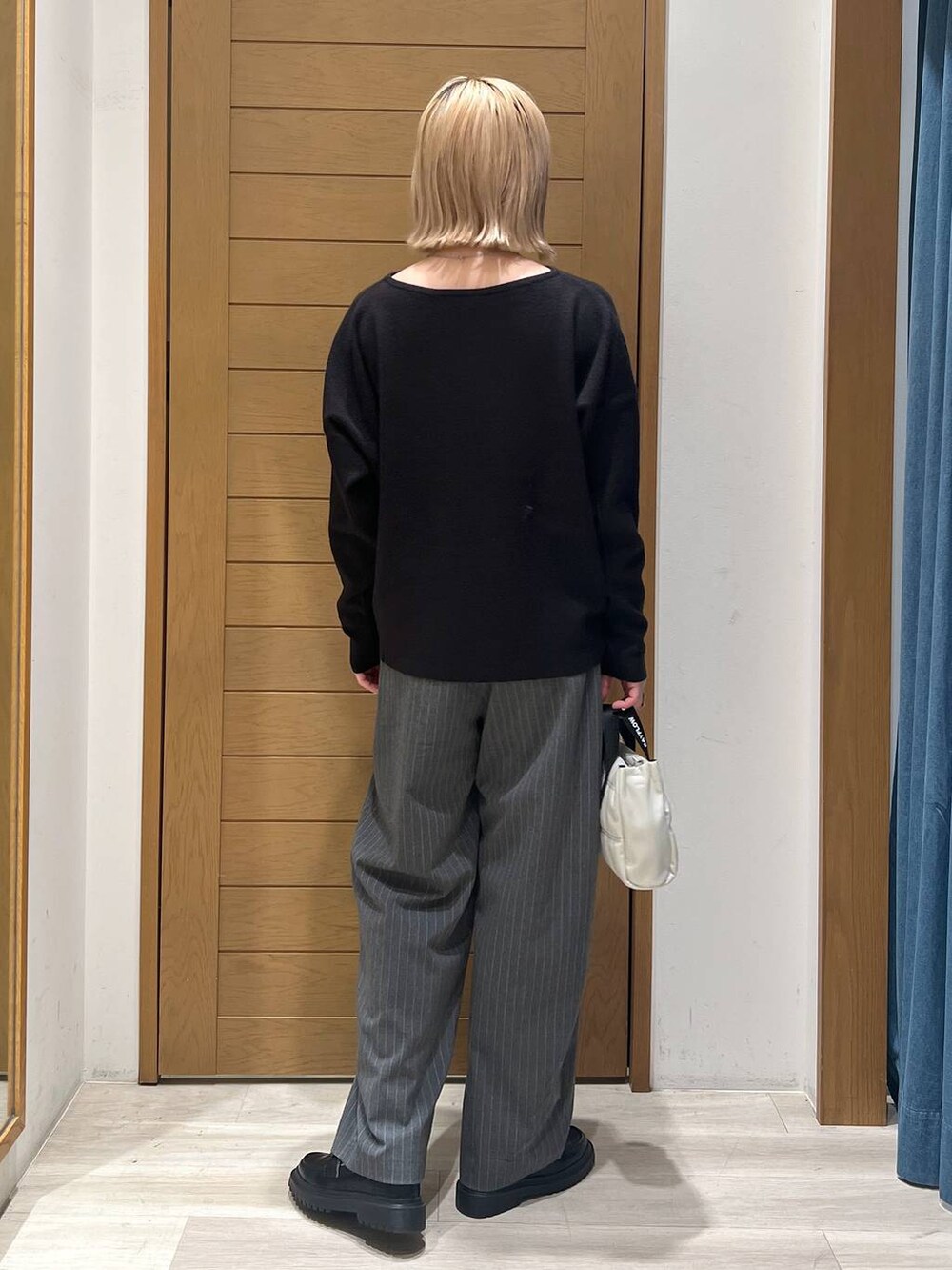 ブラック系のニット/セーター、その他のローファー、ベージュ系のショルダーバッグを着用したレディースの冬コーディネートの4枚目の写真