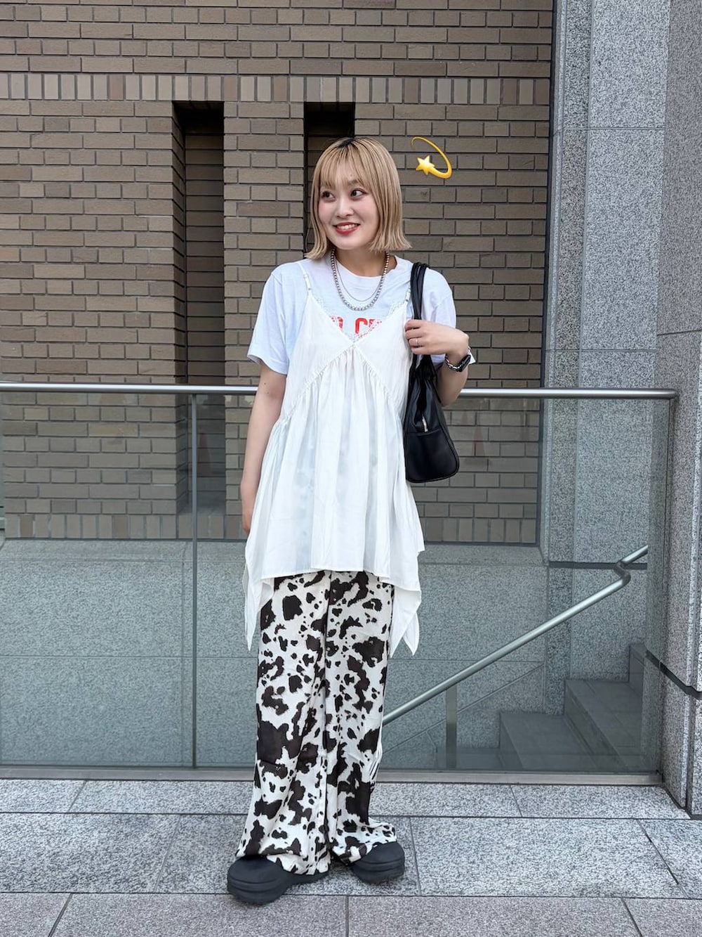 ホワイト系のチュニックを着用したレディースの夏コーディネートの3枚目の写真