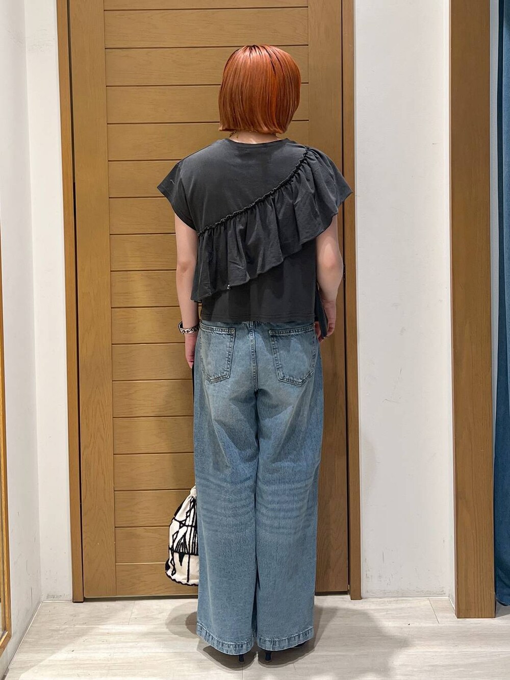 ブルー系のデニムパンツ、ブラック系のサンダル、グレー系のTシャツ/カットソーを着用したレディースの夏コーディネートの3枚目の写真