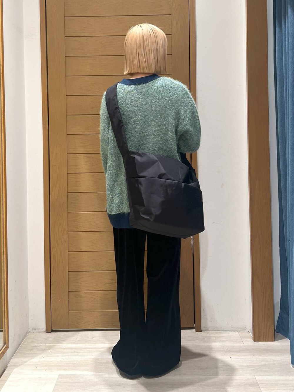 グリーン系のニット/セーター、ブラック系のショルダーバッグ、ブラック系のその他パンツを着用したレディースの冬コーディネートの4枚目の写真