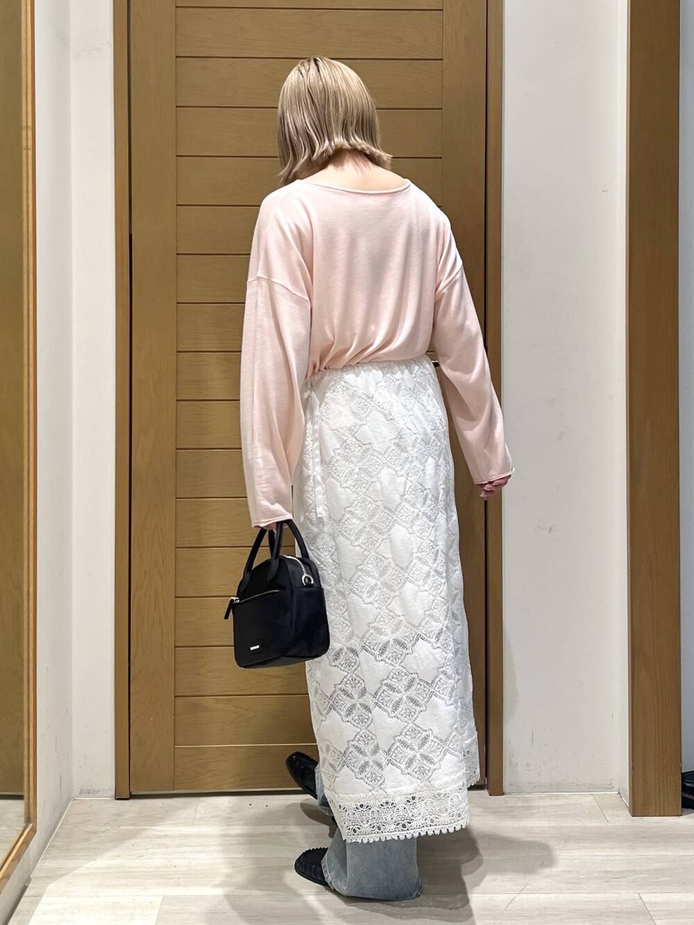 ブルー系のデニムパンツ、ブラック系のハンドバッグ、ブラック系のローファーを着用したレディースの春コーディネートの4枚目の写真