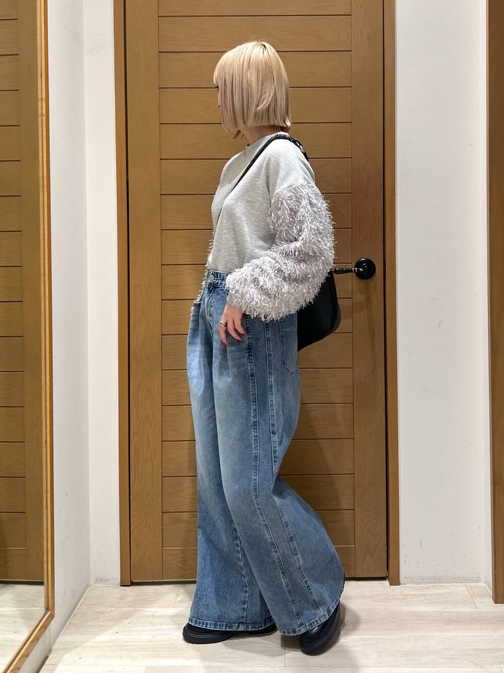 ブルー系のデニムパンツ、その他のローファー、ブラック系のショルダーバッグを着用したレディースの冬コーディネートの3枚目の写真