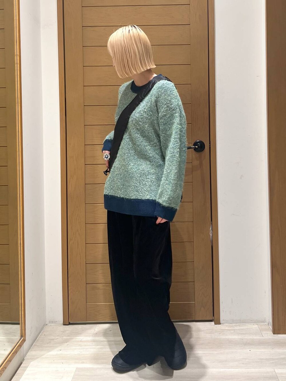 グリーン系のニット/セーター、ブラック系のショルダーバッグ、ブラック系のその他パンツを着用したレディースの冬コーディネートの3枚目の写真