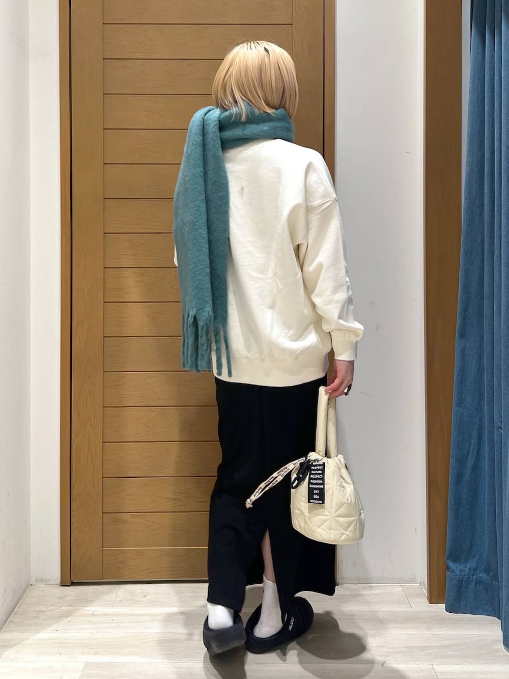 ベージュ系のショルダーバッグ、ホワイト系のスウェット、ブラック系のスカートを着用したレディースの冬コーディネートの4枚目の写真