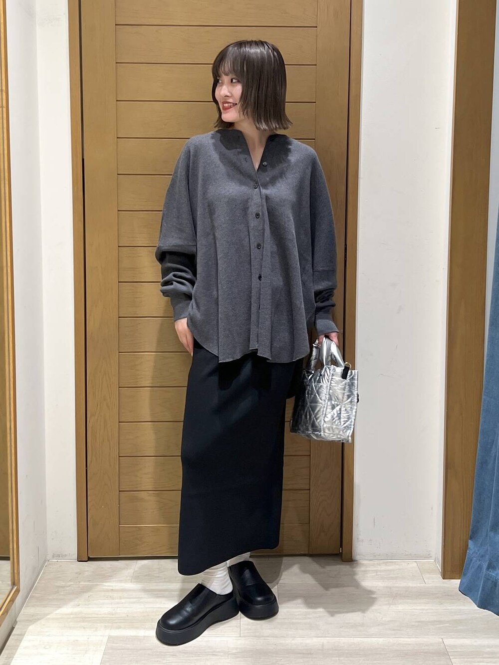 グレー系のカーディガン/ボレロ、シルバー系のショルダーバッグ、ブラック系のサンダルを着用したレディースの秋コーディネートの7枚目の写真