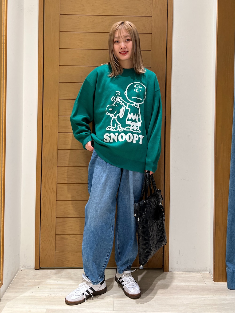 パープル系のニット/セーター、ブルー系のデニムパンツ、ブラック系のトートバッグを着用したレディースの冬コーディネートの2枚目の写真