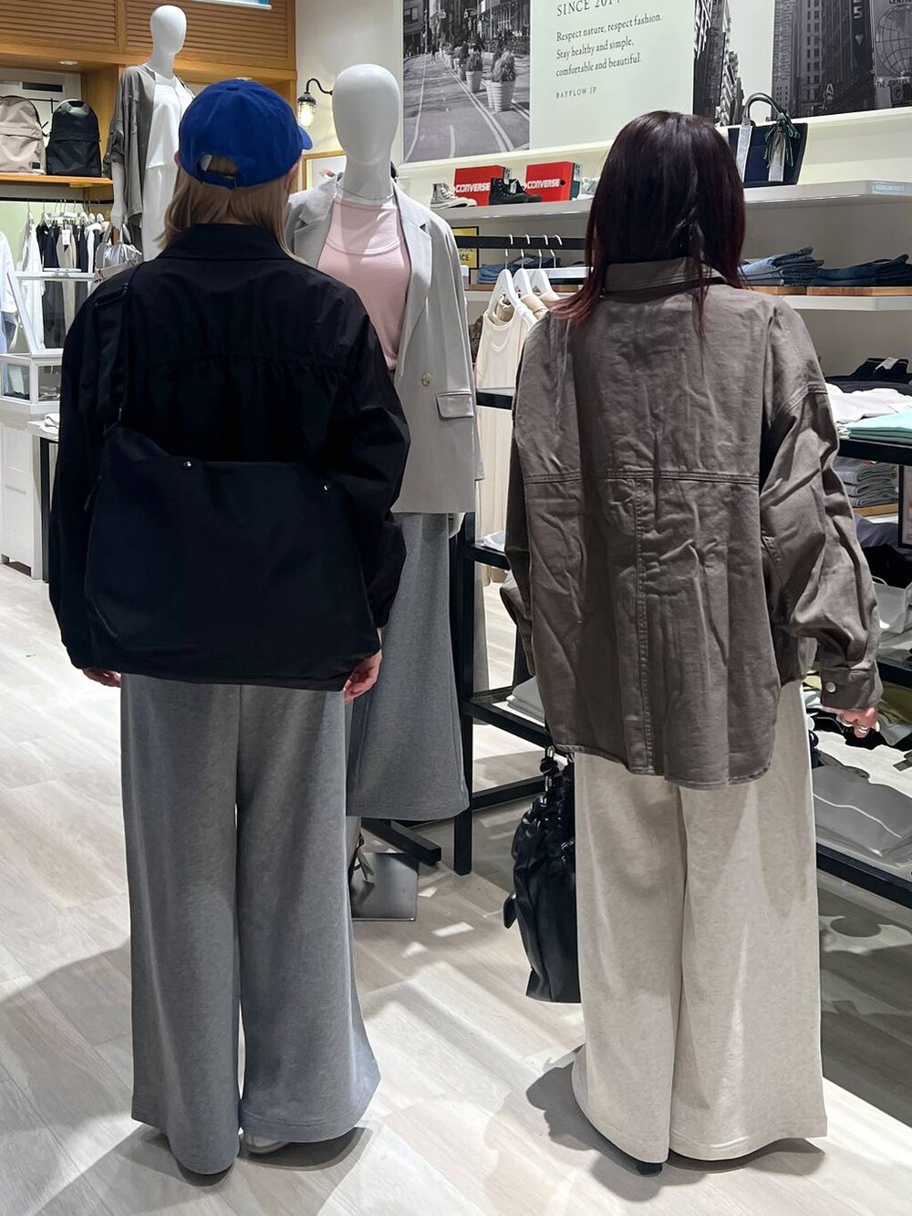 ブラック系のブルゾン、ブラック系のハンドバッグ、グリーン系のカバーオールを着用したレディースの春コーディネートの4枚目の写真