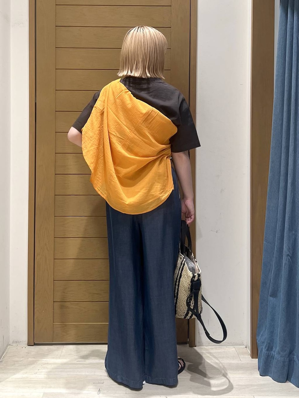 ブラック系のTシャツ/カットソー、オレンジ系のシャツ/ブラウス、ブルー系のデニムパンツを着用したレディースの春コーディネートの4枚目の写真