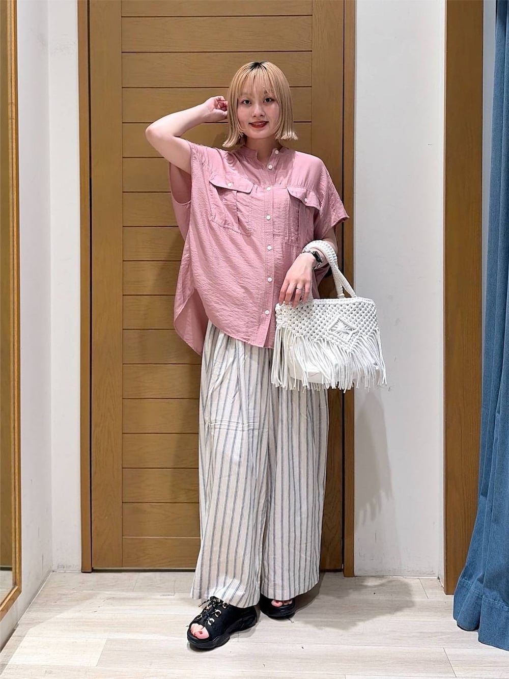 ピンク系のシャツ/ブラウス、ホワイト系のその他パンツ、ブラック系のサンダルを着用したレディースの夏コーディネートの5枚目の写真