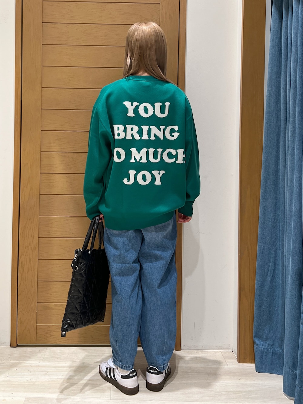 パープル系のニット/セーター、ブルー系のデニムパンツ、ブラック系のトートバッグを着用したレディースの冬コーディネートの4枚目の写真