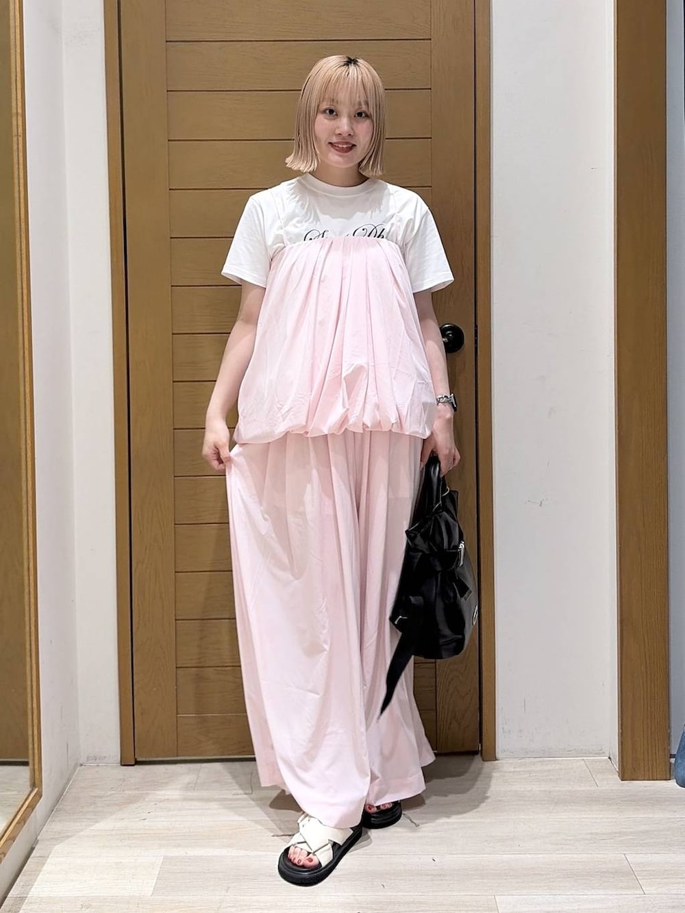 ホワイト系のTシャツ/カットソー、ブラック系のトートバッグ、ホワイト系のサンダルを着用したレディースの夏コーディネートの6枚目の写真