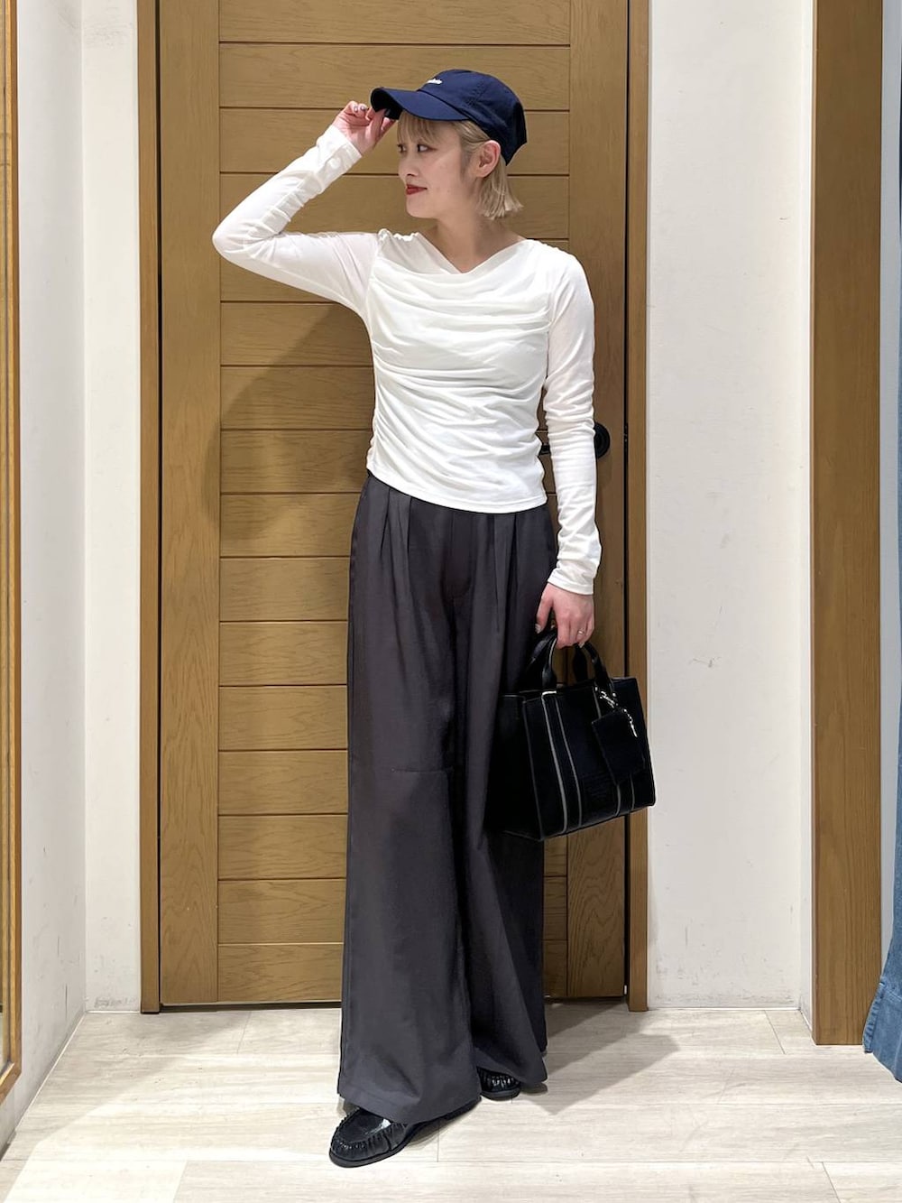 ブラック系のハンドバッグ、ブラック系のローファー、グレー系のその他パンツを着用したレディースの冬コーディネートの4枚目の写真