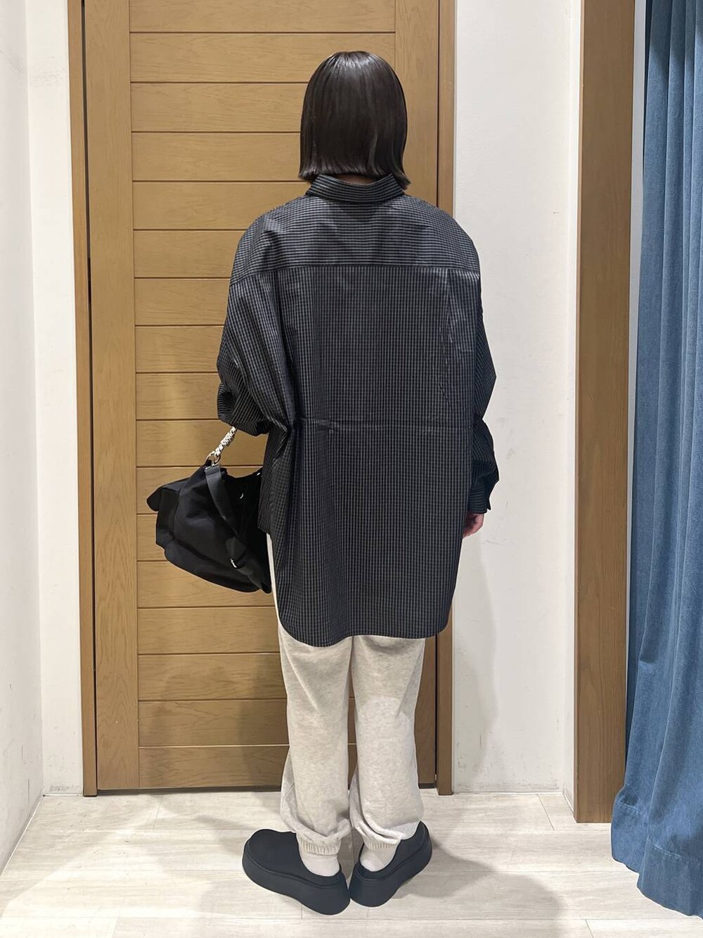 ベージュ系のスウェットパンツ、ブラック系のサンダル、ブラック系のハンドバッグを着用したレディースの秋コーディネートの4枚目の写真